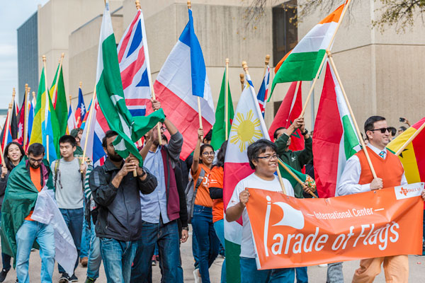 ut dallas students marching in a parade of flags