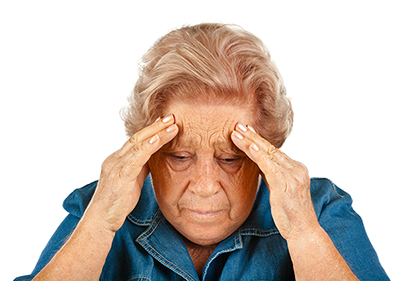 Elderly lady holding her head because of migranes.
